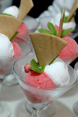 tray of fancy desserts in martini glasses with wafter and sprig of mint